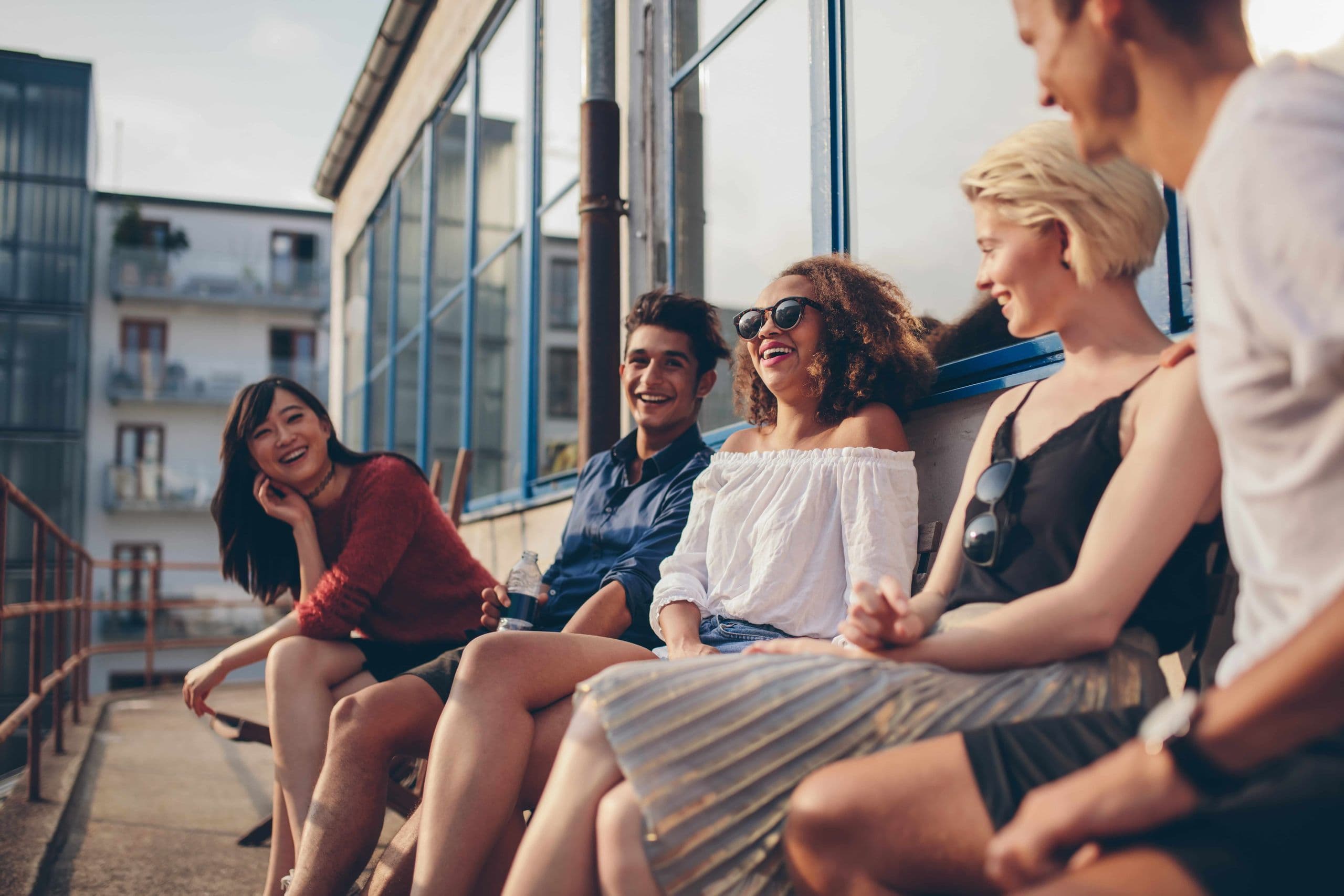 people in their 20s sitting and laughing